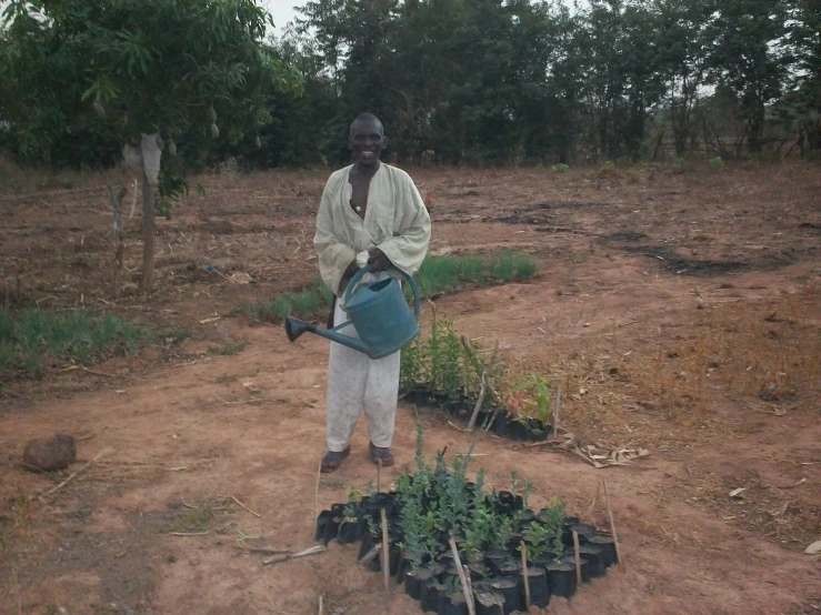 the man is watering plants in his backyard