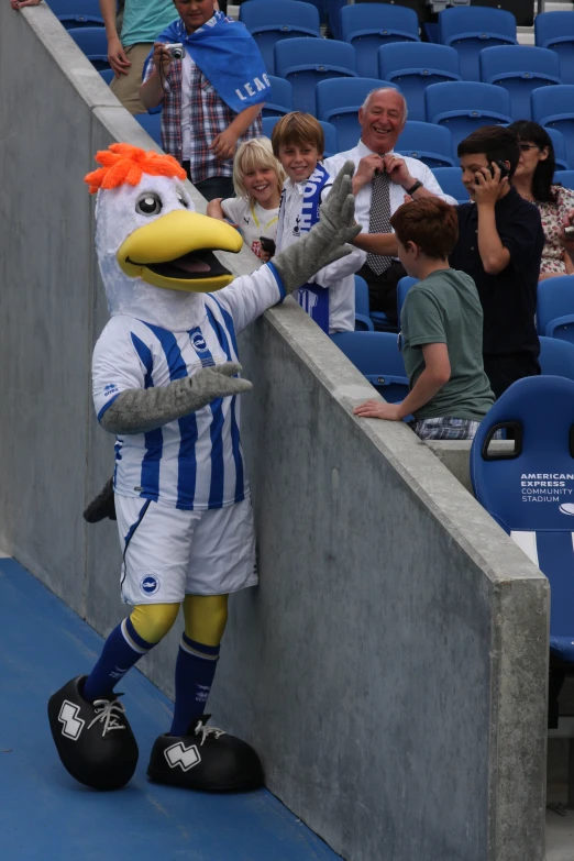 a mascot is on the side of a stadium bench