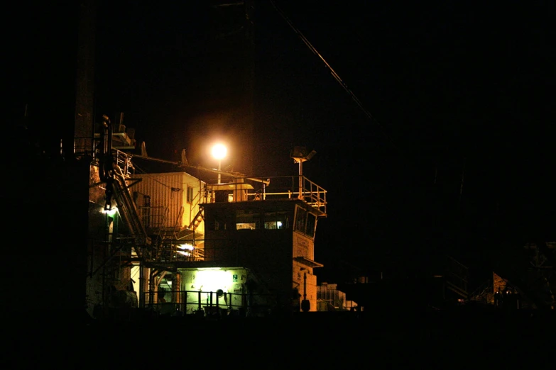 a factory lit up at night in the dark