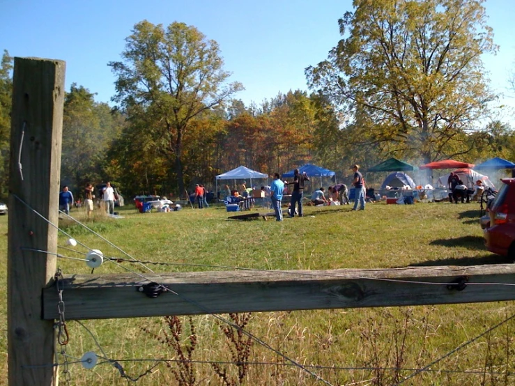 a field with several people on it and tents