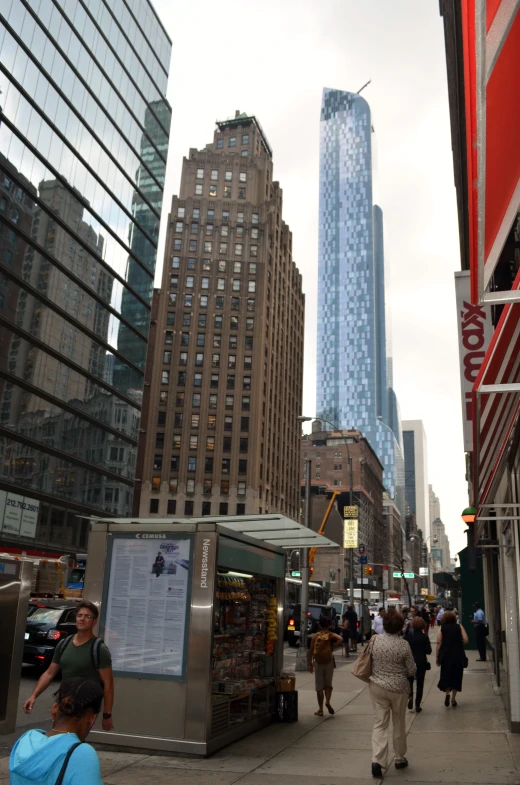 people walk down the sidewalk in a city