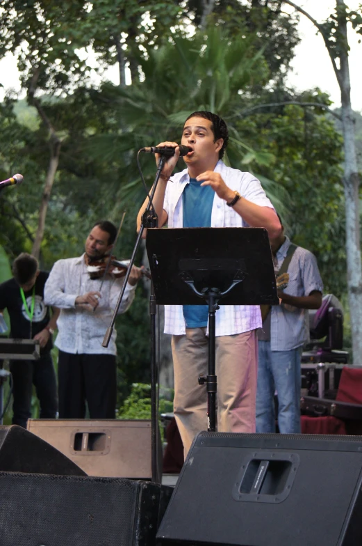 a man sings while playing music on stage