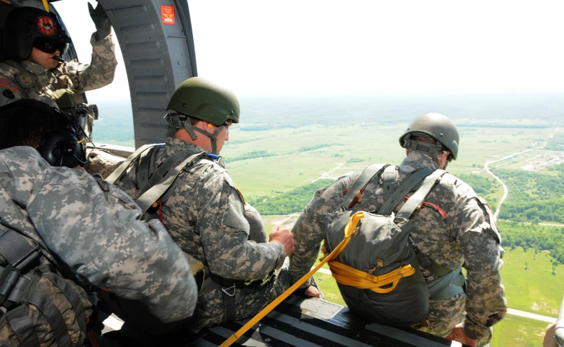 soldiers in camouflage wear standing on the deck of a helicopter