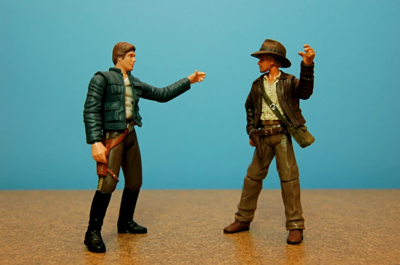 two toy figurines in action pointing towards each other