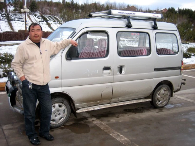 a man standing next to his van in the parking lot