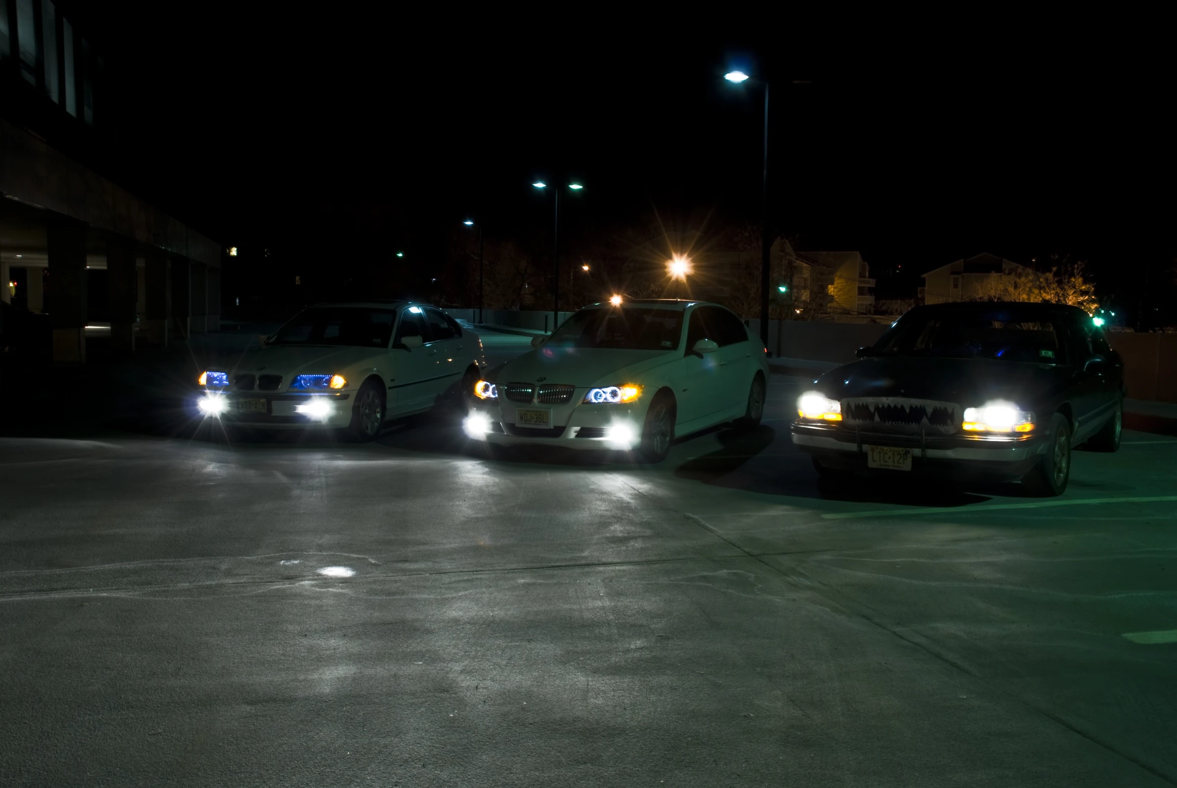 three lights are shining on cars parked in a parking lot