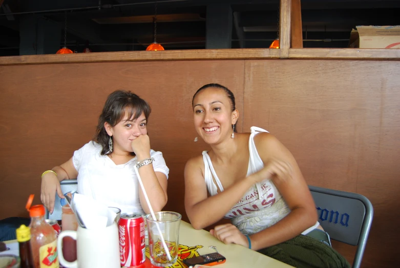 two women sitting at a table with some drinks