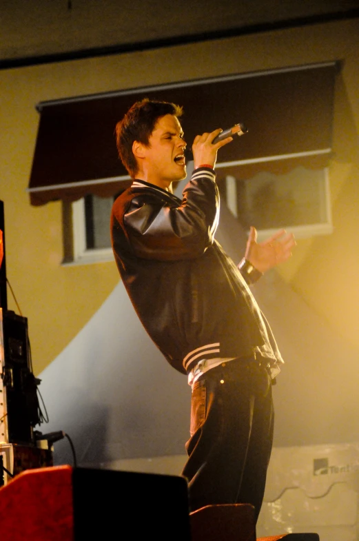 a man on stage singing and dancing