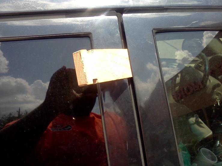 a man holding onto the glass of a vehicle