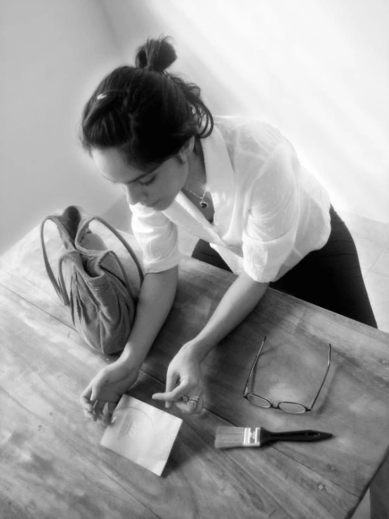 a woman on a table holding a bag and reading a book