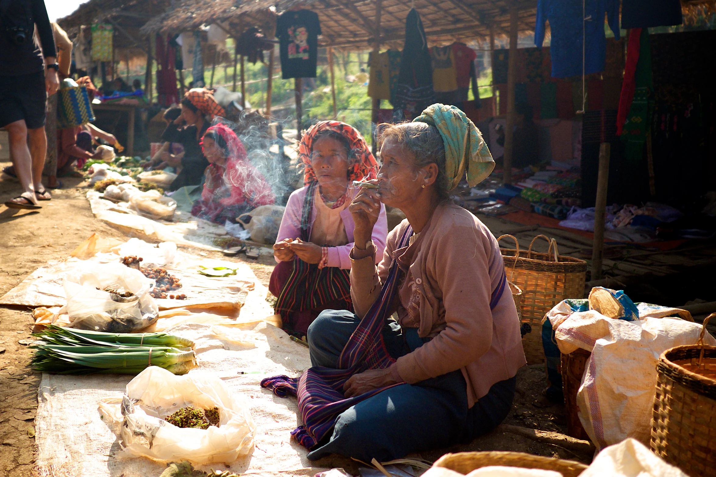 two women sitting on the ground in front of small buildings