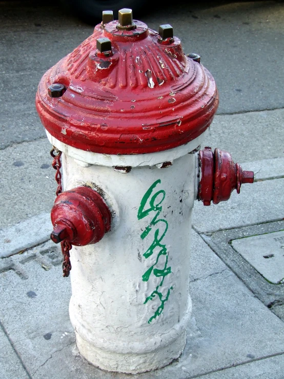 the red and white fire hydrant is painted green