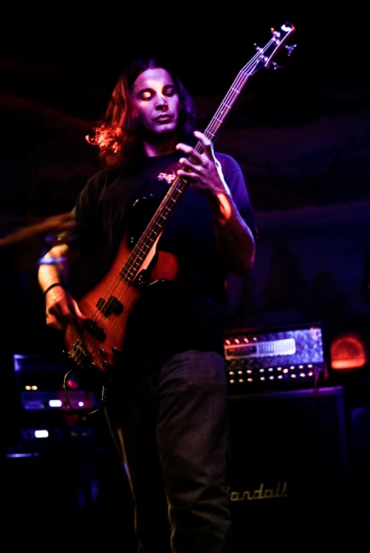 a man with long hair playing a musical instrument