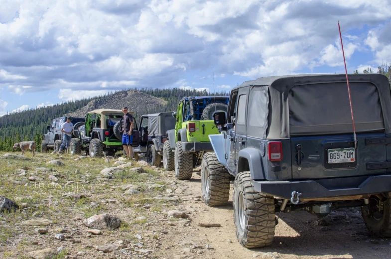 several jeeps line up in the wilderness on the trail