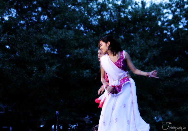 a woman in a long white dress with a flower