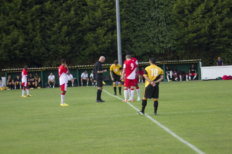 men standing around while the referee gives instructions on soccer