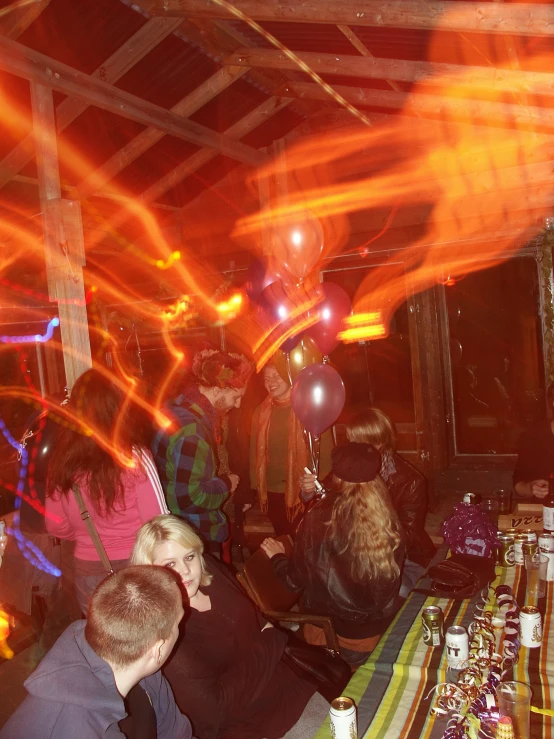 a group of people at a table with bright colored lights