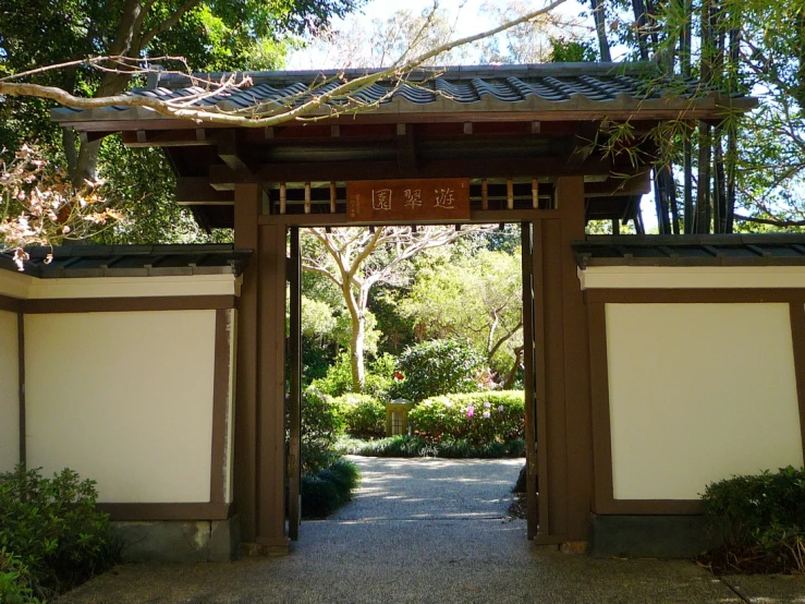 an asian styled gate with trees and plants