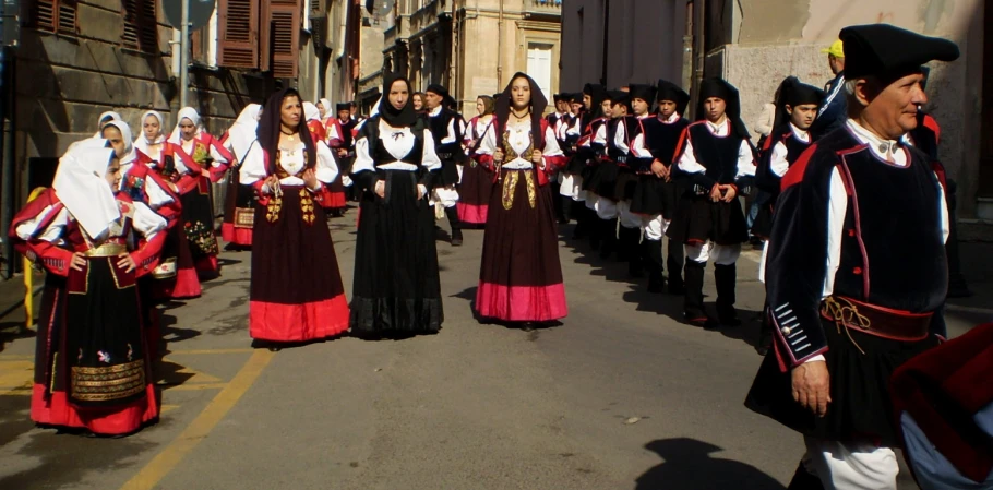 several men and women in costume are marching down the street