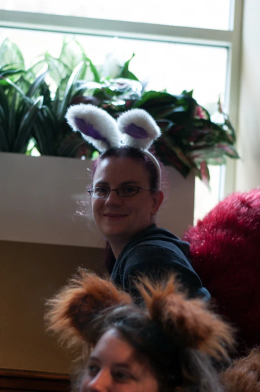 two young women standing in a room wearing fuzzy hair