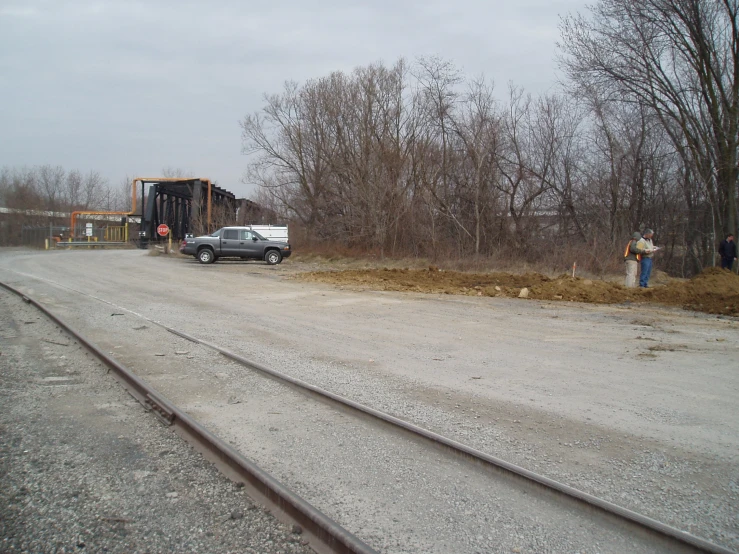 trucks are parked on the side of the railroad tracks