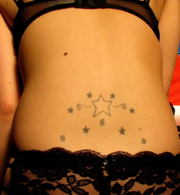a very beautiful woman's back with stars on it