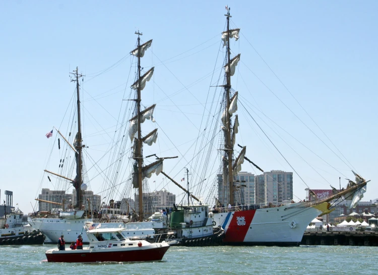 a big and smaller ship docked in the harbor