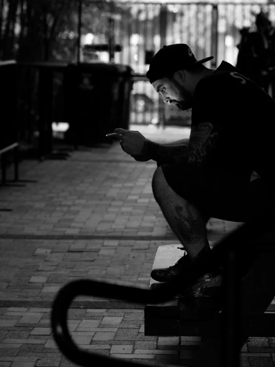 a man in shorts and a baseball cap is sitting on a bench