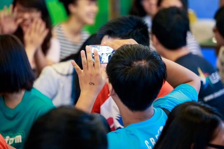 two people taking pictures of the crowd of them