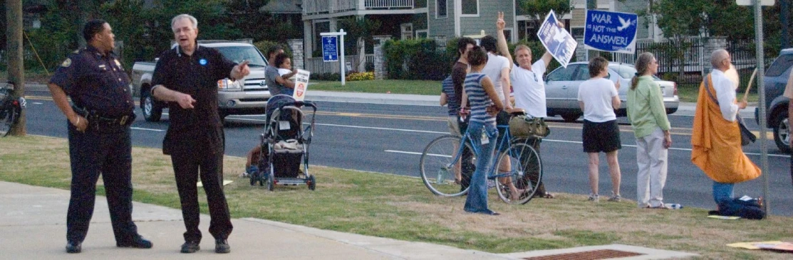 the man is speaking to people on the sidewalk