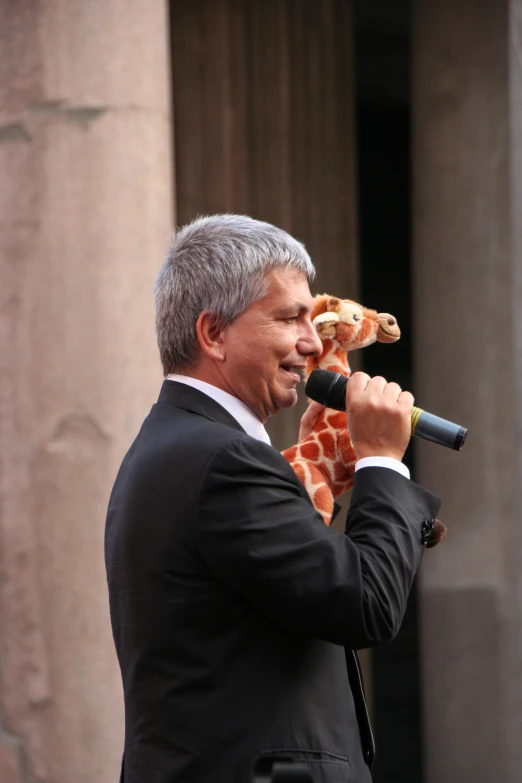 a man in suit holding up pizza slice