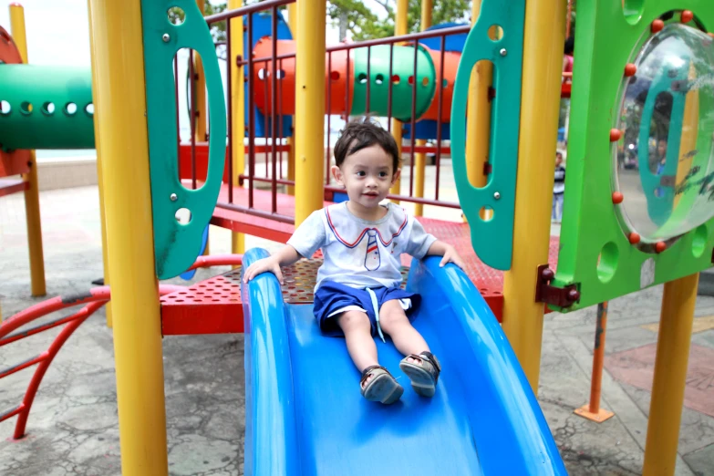 a  is sitting on a blue slide