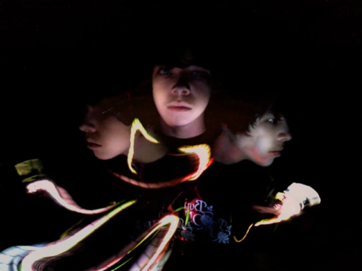 a group of young women stand together in front of a black background