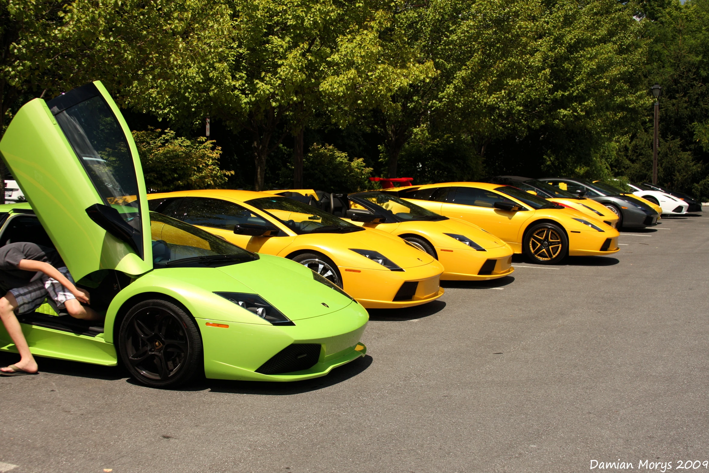 several bright cars lined up in a parking lot