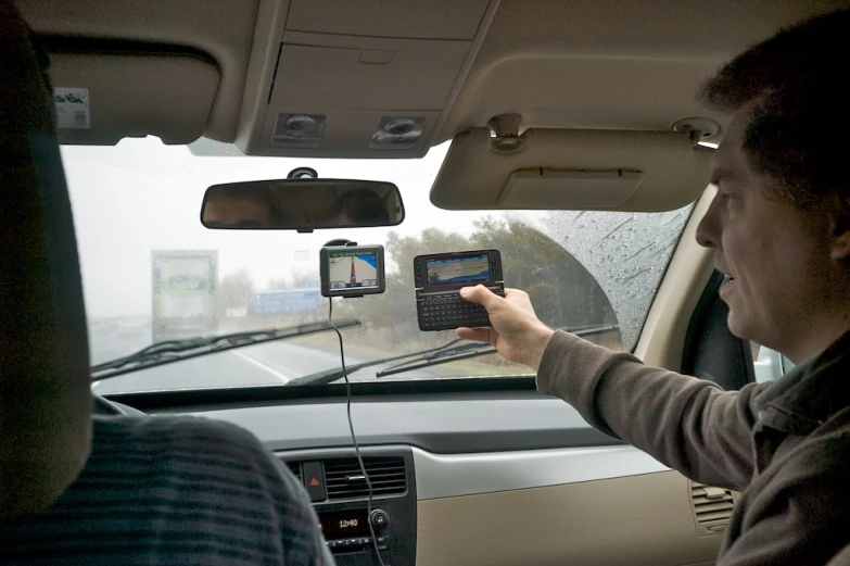 a man using a smartphone while inside a vehicle