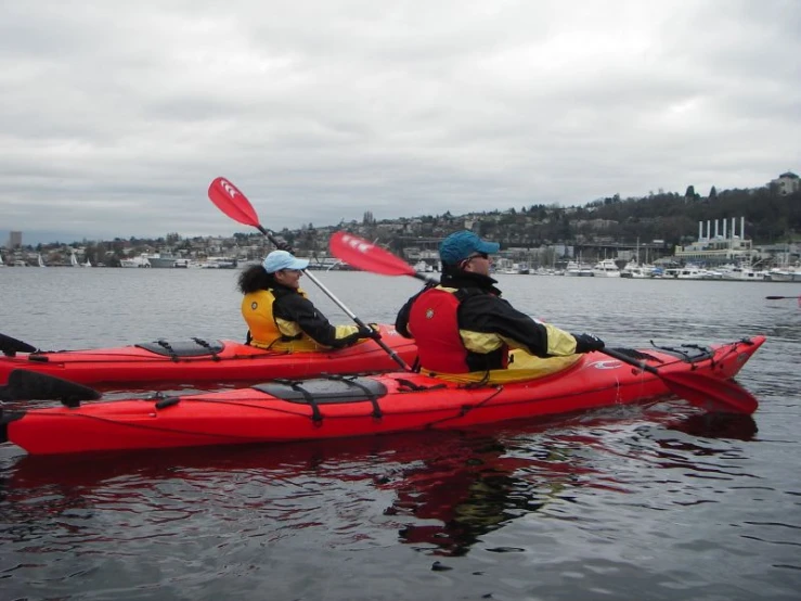 a pair of people in kayaks ride on the water