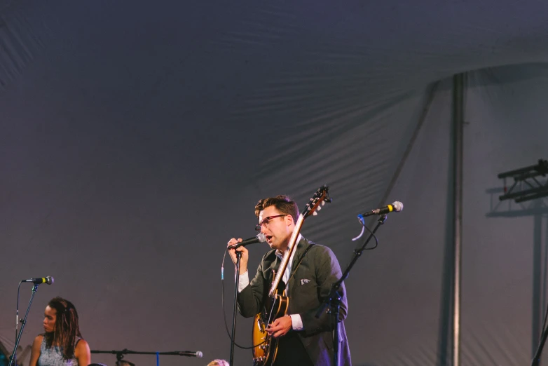 man standing on stage with an instrument in front of other men