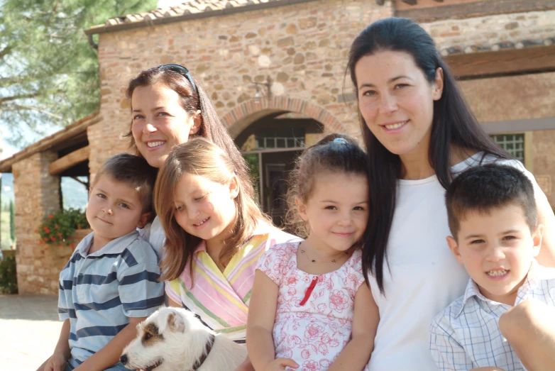 a family is standing outside their house with the dog