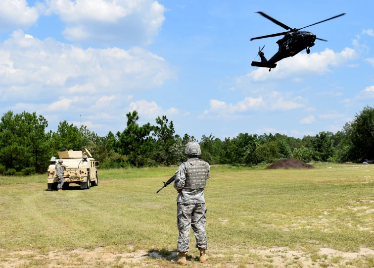 a man is looking at a military helicopter