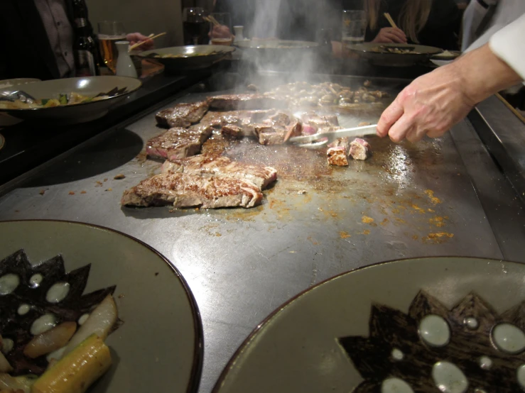 a man cooking some food on a pan on a grill