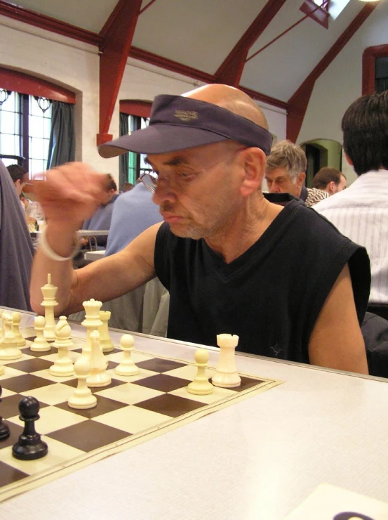 a man in a hat playing chess at a restaurant