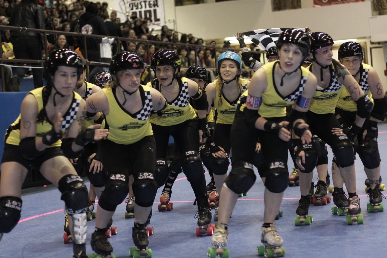 several girls with helmets on roller skates and wearing black safety equipment