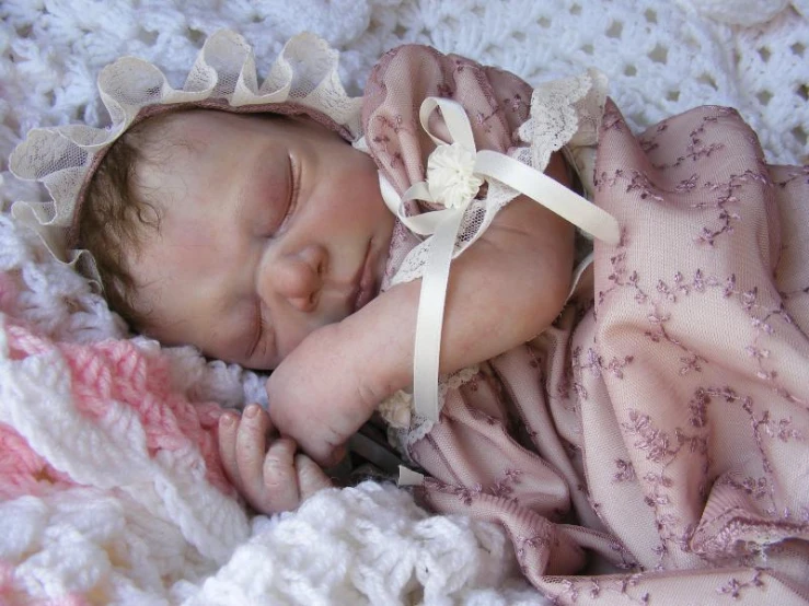 a close up of a baby laying on a blanket