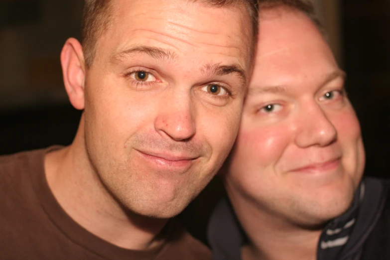 two men are posing for a selfie with camera