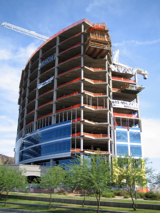 a very tall building under construction with a crane in the background