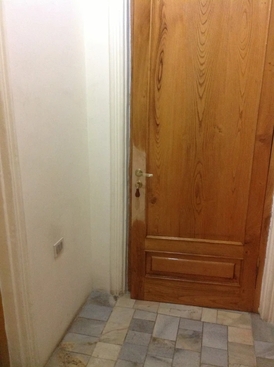 a wood door is open in a small room