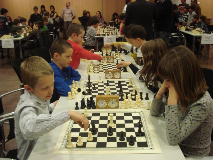 s playing chess in a large class with many spectators