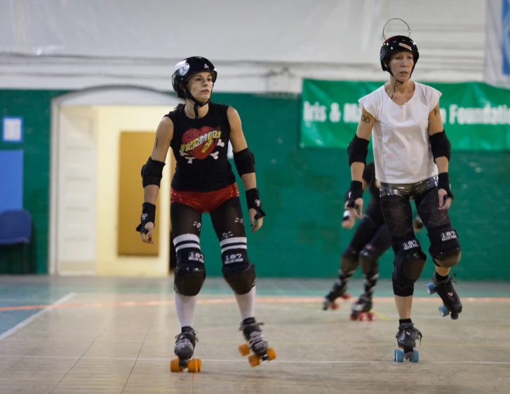 two skate boarders in an indoor setting riding their skates