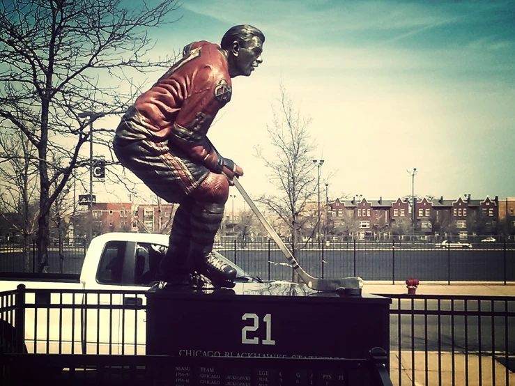 a statue of a hockey player sitting on the back of a white pickup truck