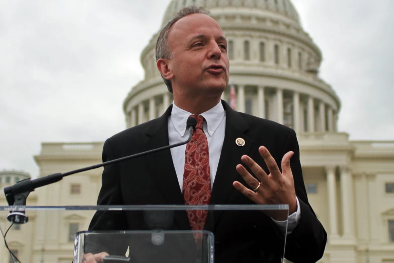 a man in a suit and tie standing at a podium